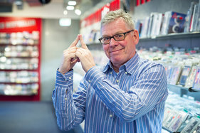 Jörg Jäger vom Pressezentrum Lübeck zeigt das Sieben-Türme-Symbol mit seinen beiden Zeigefingern
