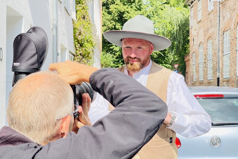Marco Quandt steht in Handwerkerkleidung vor dem Fotografen, auf dem Kopf ein heller Hut