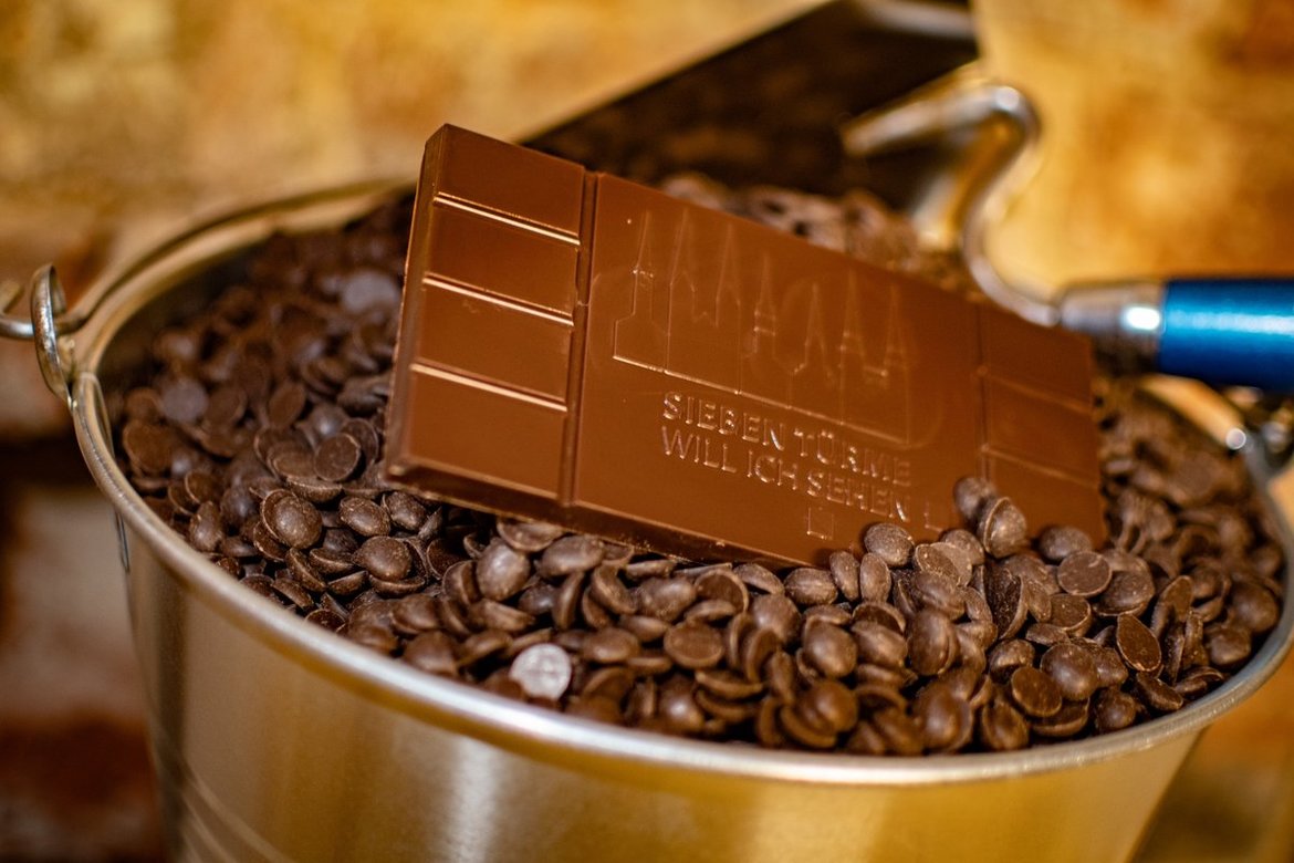 Eine Tafel Schokolade liegt in einem Eimer voll Schokoflocken.