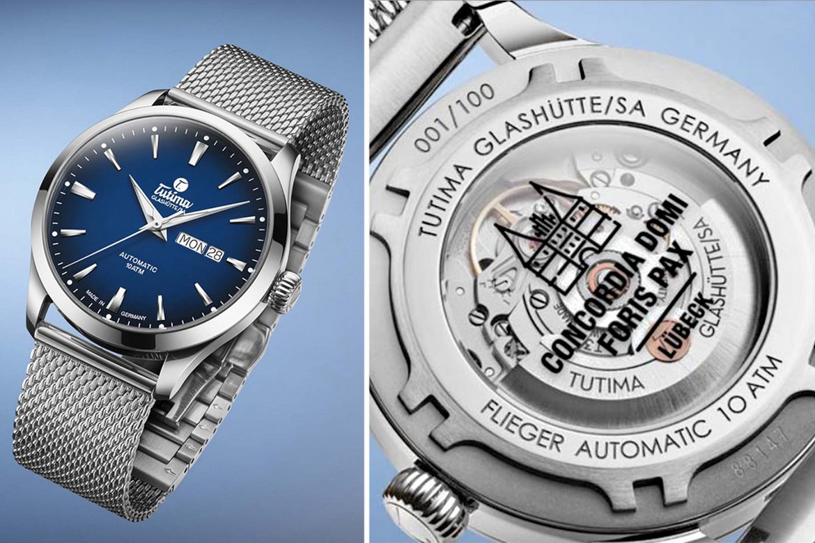 Links eine Arbanduhr in silber mit blauem Ziffernhintergrund, rechts die Rückseite der Uhr, wo das Uhrwerk zu sehen ist und der Aufdruck des Lübecker Holstentors mit Text: CONDORDIA DOMI FORIS PAX