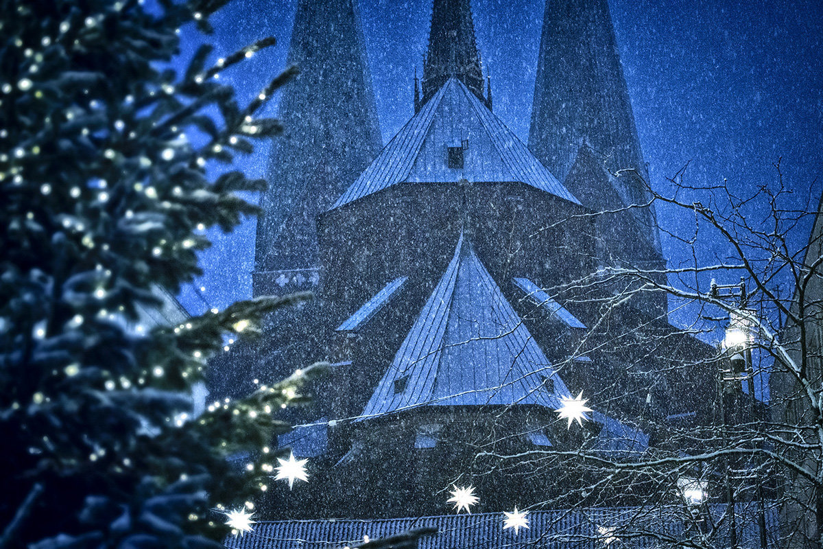 Blick durch weihnachtliches Schneegestöber auf St. Marien- Auf der linken Seite sieht man einen halbem beleuchteten Tannenbaum - Copyright: Andreas Schwiederski