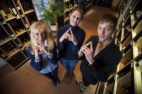 Die Mitarbeiter des Weihnaus Carl Tesdorpf Ivana Horstmann, Melanie Feldhusen und Christian Breede  machen das Sieben-Türme-Symbol mit ihren Zeigefingern. Die Finger zeigen eine Turmspitze.