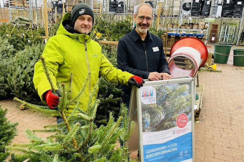 Florian Wilkop (links) und Marktleiter Frank Sämann sind im hagebau-Markt Lübeck in der Gartenabteilung. Sie präsentieren die Tannenbäumen, die zugunsten der Sieben Türme verkauft werden.
